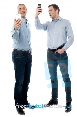 Two Young Men Using Their Phone Stock Photo