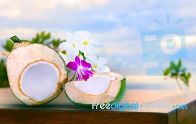 Twon Half Of Green Coconut Water On Top  Wood Table With Tropical Orchid Flowers And White  Frangipani Bouquet Decorated Stock Photo