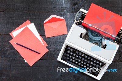 Typewriter And A Red Paper  On Wooden Background Retro Stock Photo