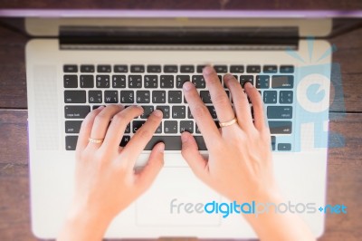 Typing On Keyboard Laptop Top View Of Wooden Table Stock Photo