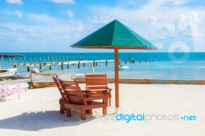 Umbrella And Chairs On The Beach In Caye Caulker, Belize Stock Photo