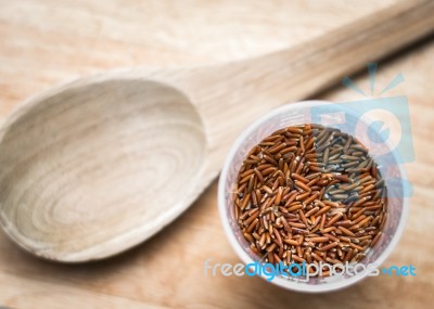 Uncooked Brown Rice In A Cup With Wooden Ladle Stock Photo