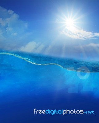 Under Blue Water With Sun Shining Above Stock Photo