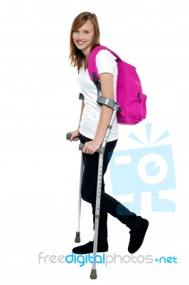 University Student Walking With Help Of Crutches Stock Photo