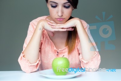 Upset Brunette Woman With Green Apple On A Plate Stock Photo