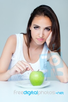 Upset Brunette Woman With Green Apple On A Plate Stock Photo