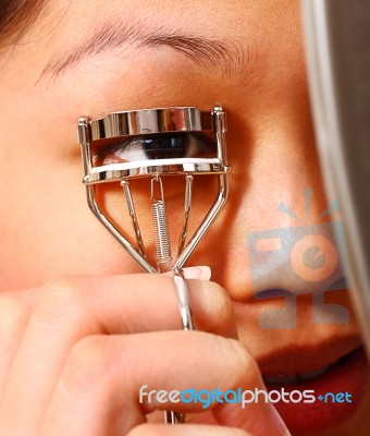 Using Curler To Curl Her Eyelashes Stock Photo