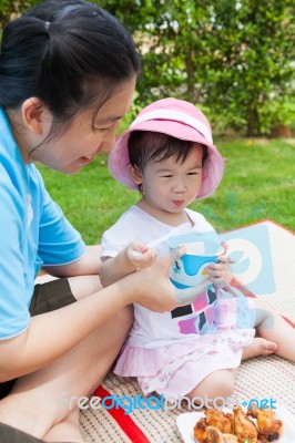 Vacation, Mother And Little Asian Girl Enjoy Eating Their Lunch Stock Photo