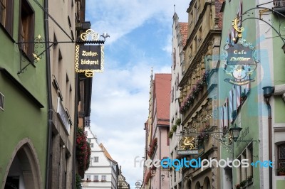 Various Hanging Signs In Rothenburg Stock Photo