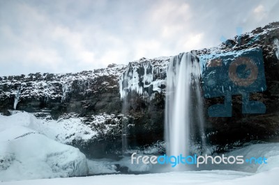 View Of Seljalandfoss Waterfall In Winter Stock Photo