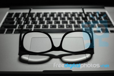 Vintage Eye Glasses On Laptop Trackpad Low Key Light Stock Photo