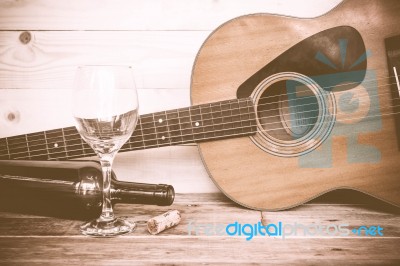 Vintage Guitar With Wine Bottle And Glass On The Old Wood Floor Stock Photo