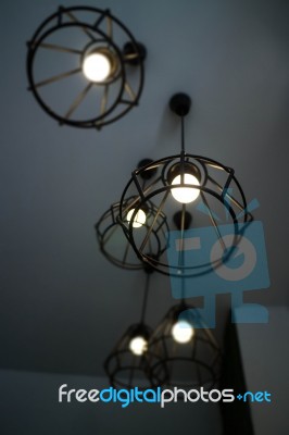 Vintage Hanging Light Bulb Over Grey Room Stock Photo