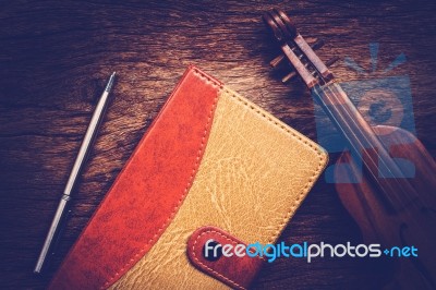 Violin And Notebook With Pen On Grunge Dark Wood Background Stock Photo