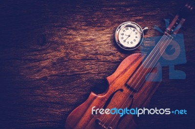 Violin And Pocket Watch On Grunge Dark Wood Background Stock Photo