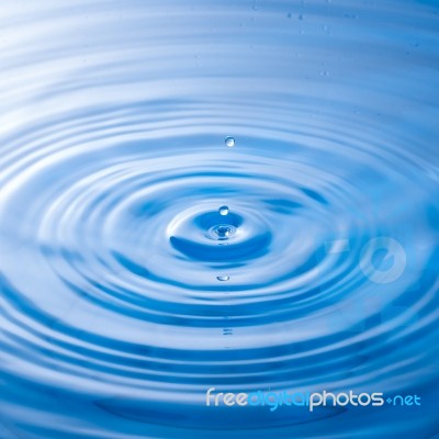 Water Drop Falling Into Water Making A Perfect Droplet Splash Stock Photo