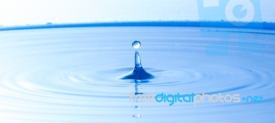 Water Drop Falling Into Water Making A Perfect Droplet Splash Stock Photo