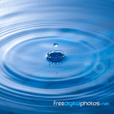 Water Drop Falling Into Water Making A Perfect Droplet Splash Stock Photo