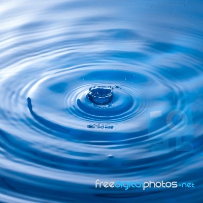 Water Drop Impact With Water Surface, Causing Rings On The Surface Stock Photo