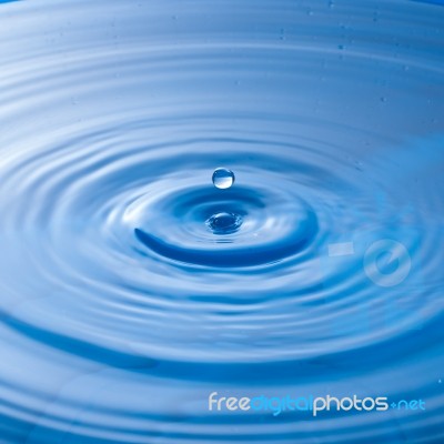 Water Drop Impact With Water Surface, Causing Rings On The Surface Stock Photo