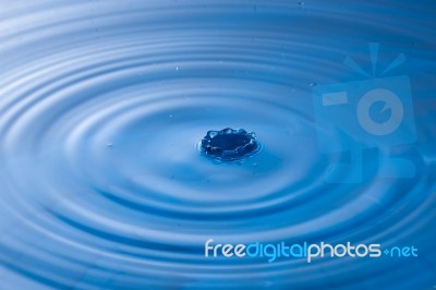 Water Drop Impact With Water Surface, Causing Rings On The Surface Stock Photo