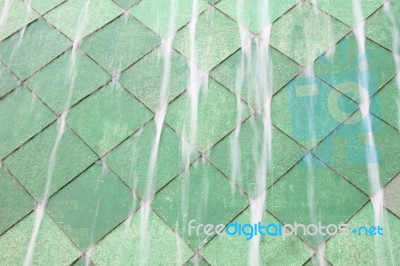 Water Fall On Green Tile Wall Stock Photo