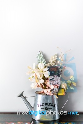 Watering Can Filled With Flower And Bear Doll Stock Photo