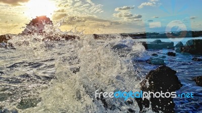 Wave Shattering On Rocks Stock Photo