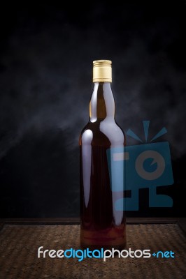 Whiskey Bottle On Wood Background Stock Photo