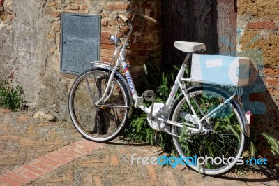 White Bicycle Leaning Against A Wall In Pienza Tuscany Stock Photo