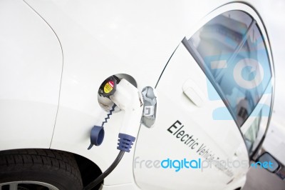 White Electric Car Charging Stock Photo