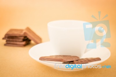 White Mug Of Hot Coffee And Chocolate Pieces Stock Photo