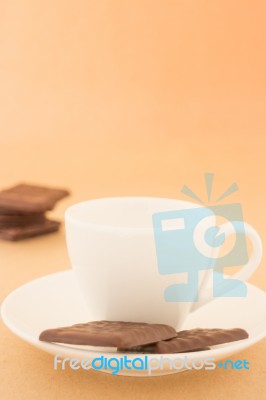 White Mug Of Hot Coffee And Chocolate Pieces Stock Photo