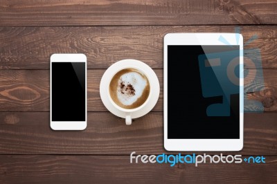 White Phone Tablet And Coffee Cup On Wood Table Top View Stock Photo