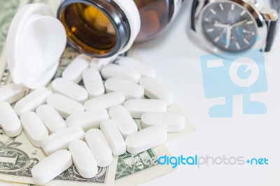 White Pills And Money On White Background Stock Photo