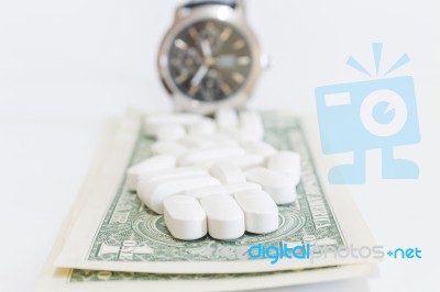 White Pills And Money On White Background Stock Photo