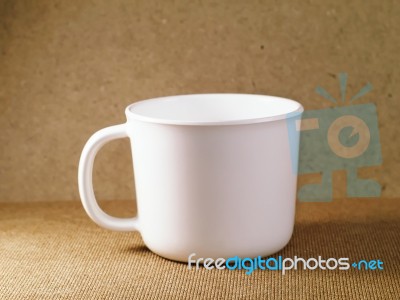 White Plastic Cup On A Wooden Board Stock Photo