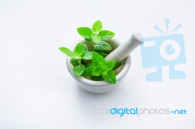 White Porcelain Mortar And Pestle With Peppermint Leaf On White Stock Photo