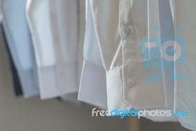 White Shirts Hanging On Rack Stock Photo