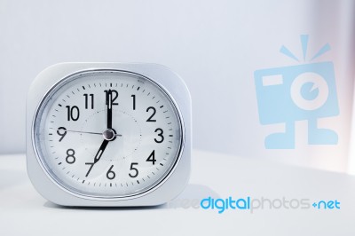 White Square Clock On White Bed Stand With White Wallpaper Background, Morning Time In Minimal Style Decoration Stock Photo