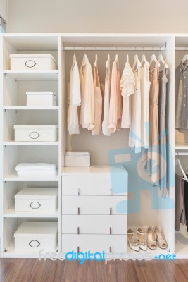 White Wardrobe On Wooden Floor With Dress Stock Photo