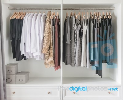 White Wardrobe With Clothes Hanging Stock Photo