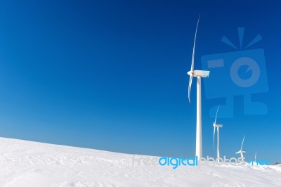 Wind Turbine And Blue Sky In Winter Landscape Stock Photo