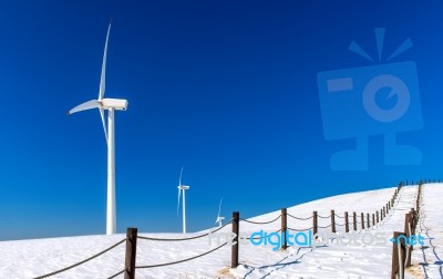 Wind Turbine And Blue Sky In Winter Landscape Stock Photo