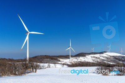 Wind Turbine And Blue Sky In Winter Landscape Stock Photo