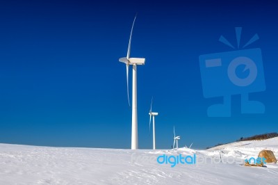 Wind Turbine And Blue Sky In Winter Landscape Stock Photo