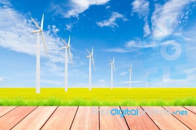 Wind Turbine On Green Rice Field Against Blue Sky Background Stock Photo