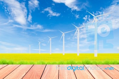 Wind Turbine On Green Rice Field Against Blue Sky Background Stock Photo