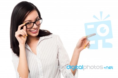 Woman Adjusting Her Spectacles And Pointing Away Stock Photo