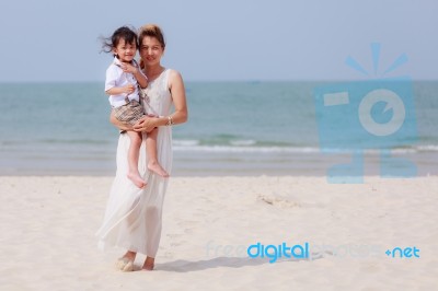 Woman And Son Walking On Beach Stock Photo